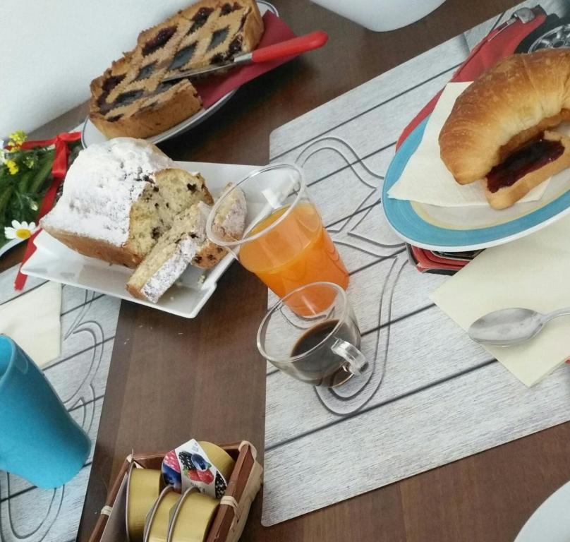 une table recouverte de assiettes de nourriture et de verres de jus d'orange dans l'établissement b&b la vecchia 500, à Pignola