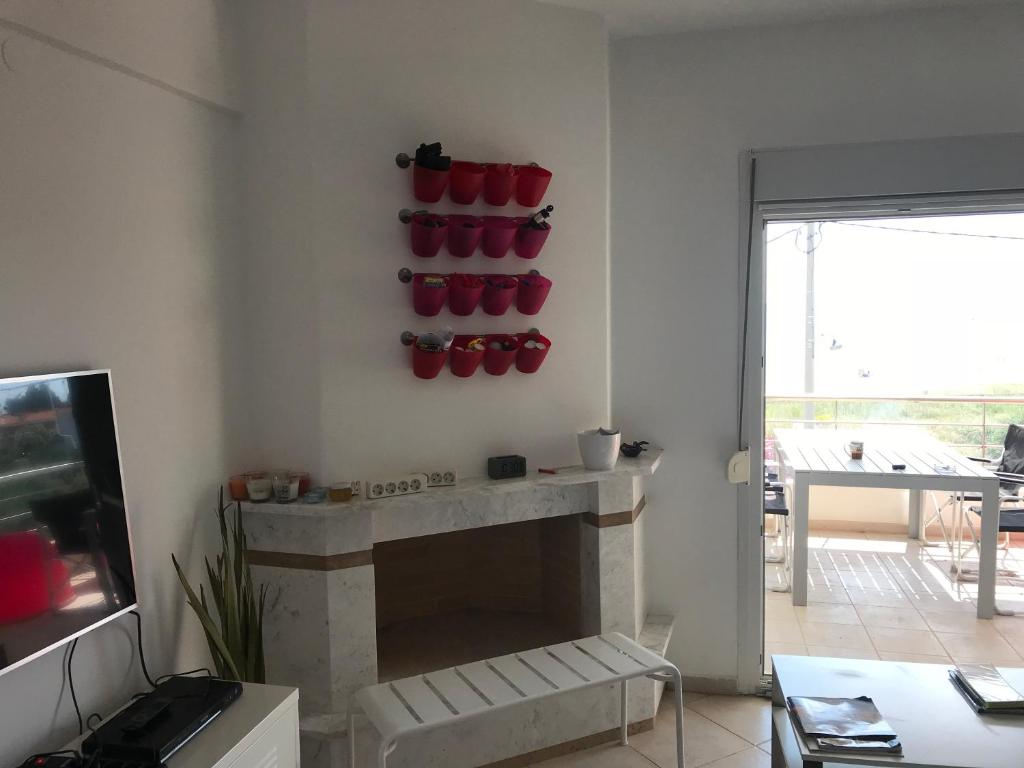 salon z kominkiem z czerwonymi garnkami na ścianie w obiekcie Chalkidiki Olivia Beach w mieście Gerakini