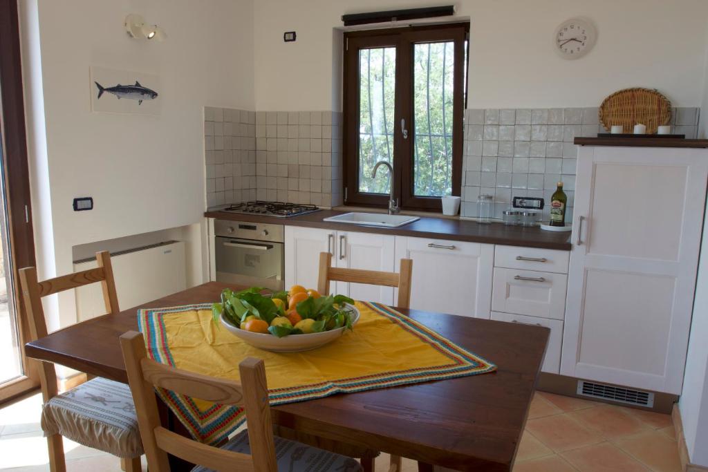 una cocina con una mesa con un bol de fruta. en La Torretta, en Casal Velino