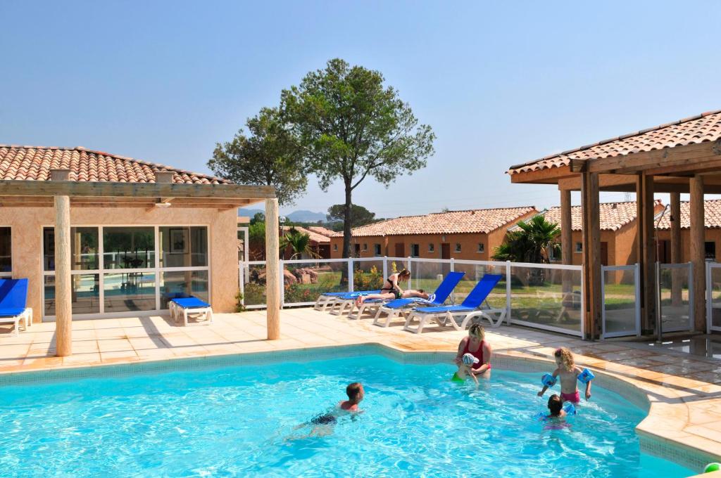 a group of people playing in a swimming pool at Résidence Goélia Le Village Azur in Puget-sur-Argens