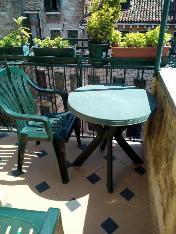 a green table and a chair on a patio at Hotel Diana in Venice