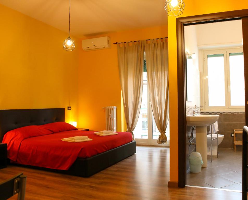 una camera con letto rosso e un bagno di Nonna's house a Roma
