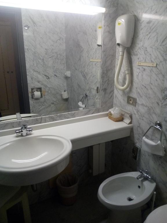 a bathroom with a sink and a toilet and a mirror at Hotel Diana in Venice