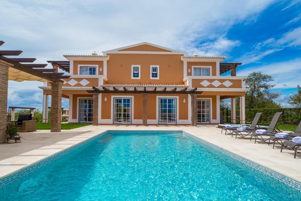 une villa avec une piscine en face d'une maison dans l'établissement Colina da Lapa & Villas, à Carvoeiro