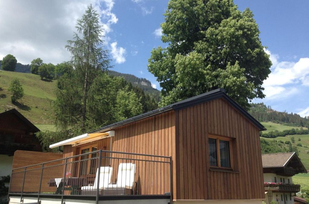 dom z białymi krzesłami na balkonie w obiekcie Chalet Schiederhof w mieście Grossarl