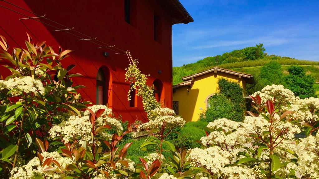 a red and yellow building with flowers in front of it at Bio-Agriturismo Carpareto in San Miniato