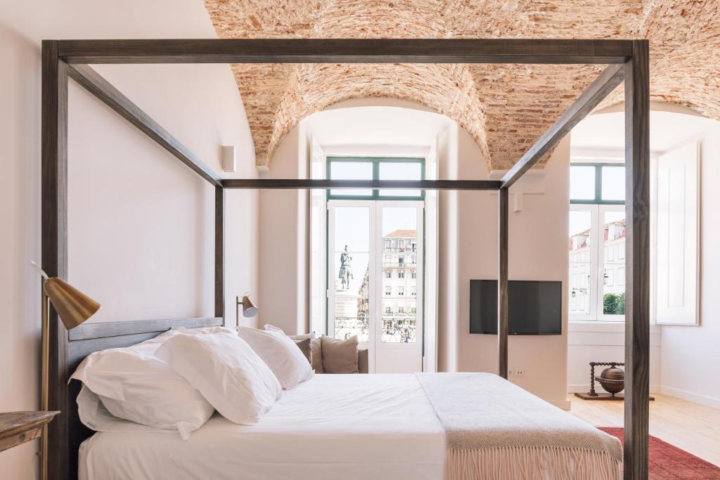 a bedroom with a large bed with a brick wall at The Visionaire Apartments in Lisbon