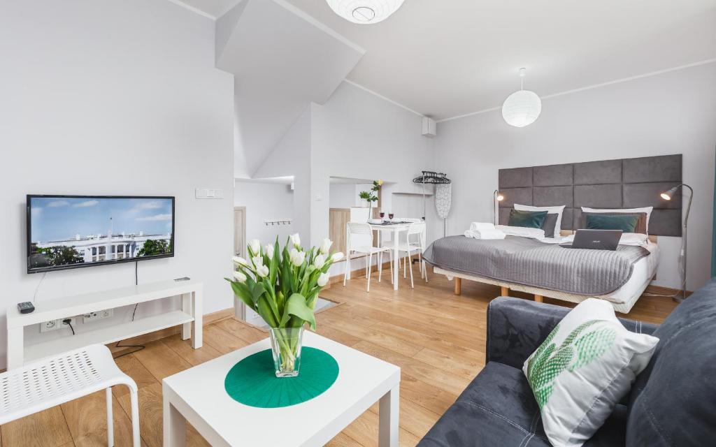 - un salon avec un canapé et un lit dans l'établissement Flower Residence, à Cracovie