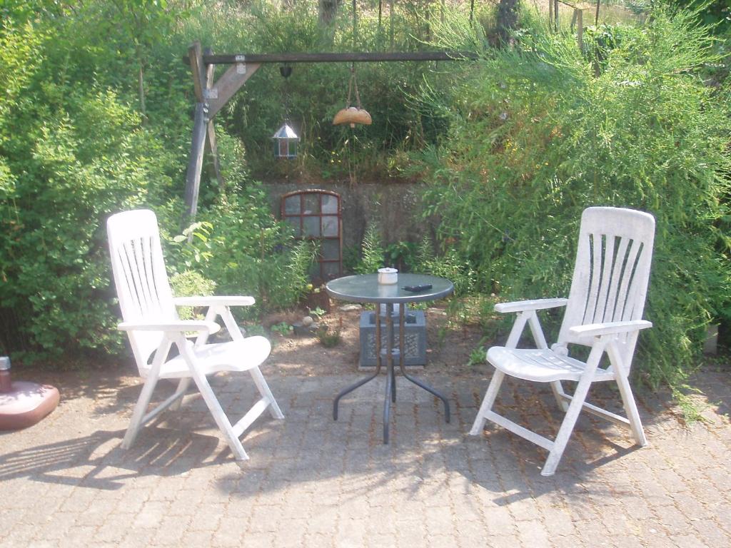 einen Tisch und zwei Stühle sowie einen Tisch und Stühle in der Unterkunft Glyngøre Bed & Breakfast in Glyngøre