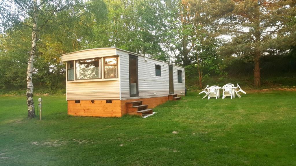 ein winziges Haus mit einem Picknicktisch auf einem Feld in der Unterkunft Camping de la Reuille in Fléré-la-Rivière