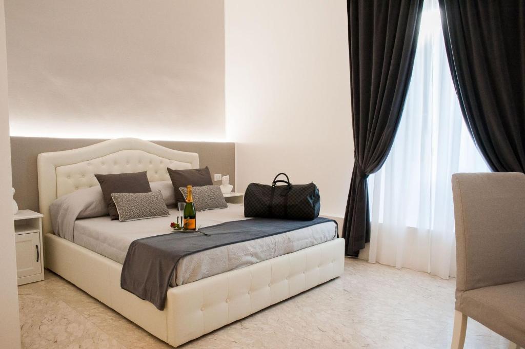 Un dormitorio con una cama con una botella de vino. en Lifestyle Veneto Suite en Roma