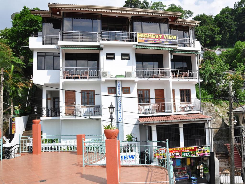 Un bâtiment blanc avec un panneau. dans l'établissement Highest View, à Kandy