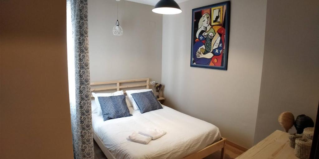チクラナ・デ・ラ・フロンテーラにあるZambra. Luminoso y coqueto apartamento en Chiclanaの小さなベッドルーム(白いシーツと青い枕のベッド付)