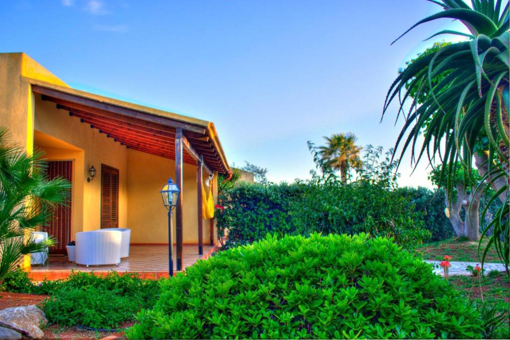 a house with a porch with bushes and trees at I Giardini di San Vito lo Capo in San Vito lo Capo