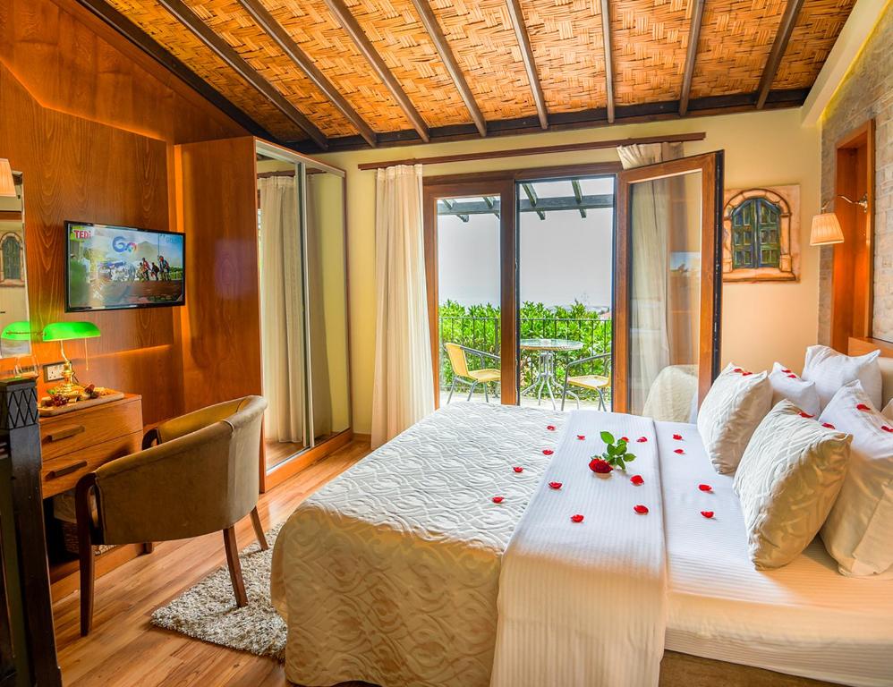 ein Schlafzimmer mit einem großen Bett mit Rosen darauf in der Unterkunft Bellapais Gardens in Kyrenia