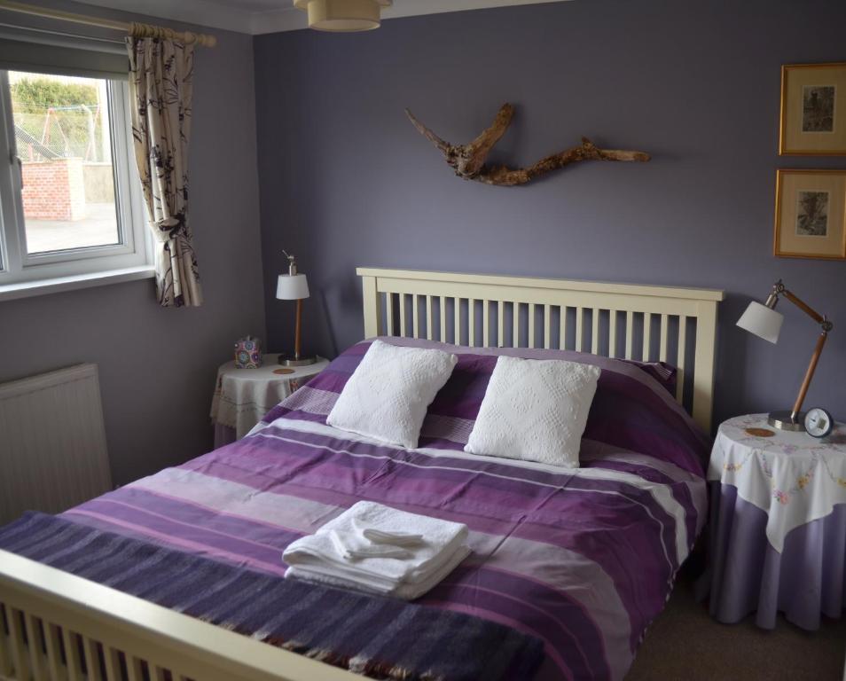 カーディガンにあるGwynfroのベッドルーム1室(紫色のベッド1台、タオル付)