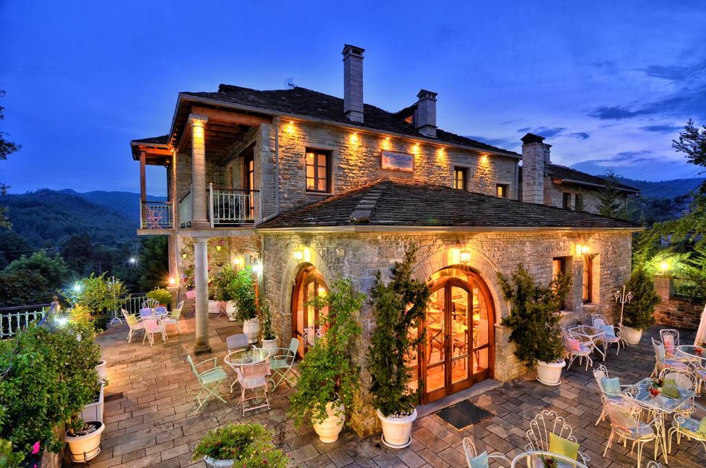 a house with a patio with tables and chairs at Melinas Boutique Hotel B&B in Kipoi