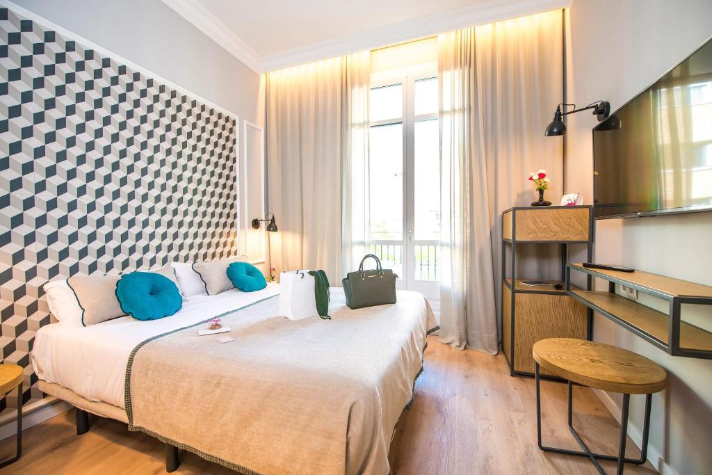 um quarto de hotel com uma cama grande com almofadas azuis em Mosaic Barcelona by Ona em Barcelona