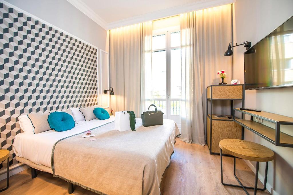 Habitación de hotel con cama grande con almohadas azules en Mosaic Barcelona by Ona, en Barcelona