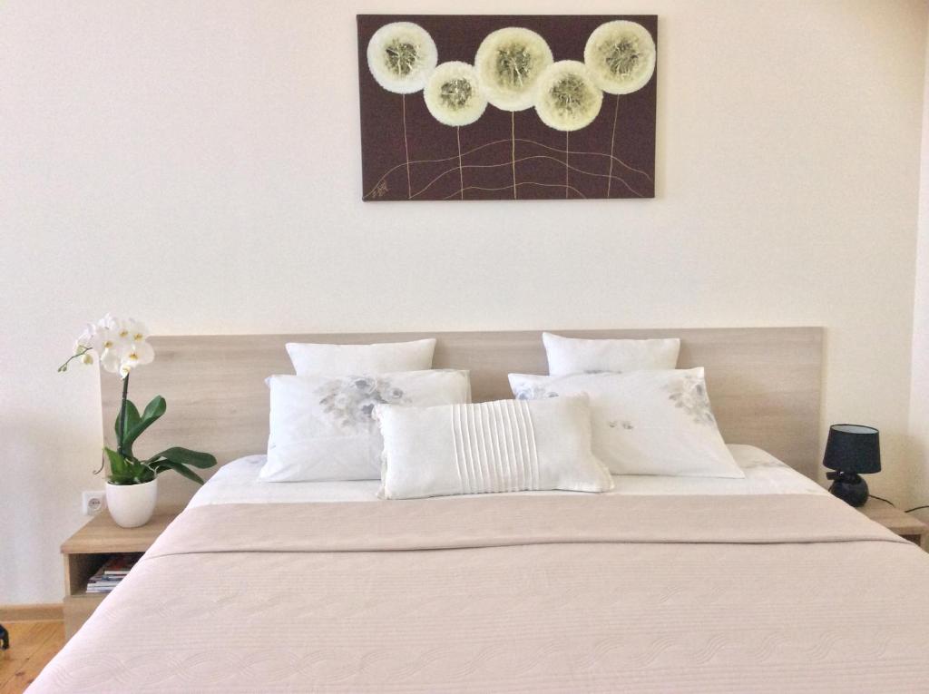 um quarto com uma cama grande e almofadas brancas em Kranto Luxe Stay em Panevėžys