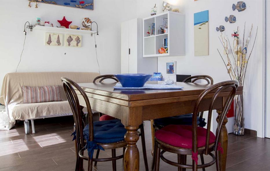 a dining room table with chairs and a blue bowl on it at la casa di anita in Rio Marina