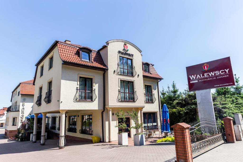 un edificio con una señal delante de él en Hotel Walewscy en Gdańsk-Rębiechowo