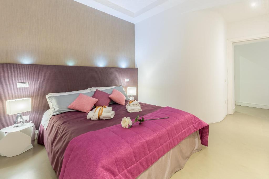 a bedroom with a pink bed with two stuffed animals on it at Silver Spanish's steps in Rome