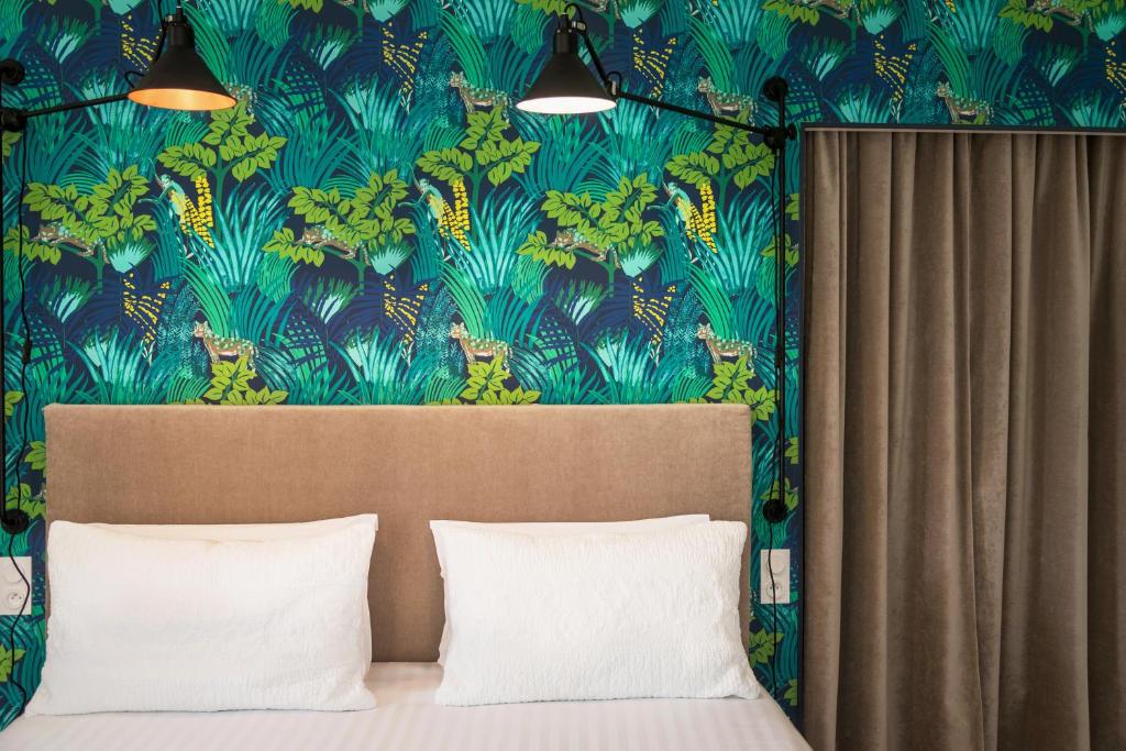 a bedroom with a bed with a blue and green wallpaper at Hotel Edouard VII in Biarritz