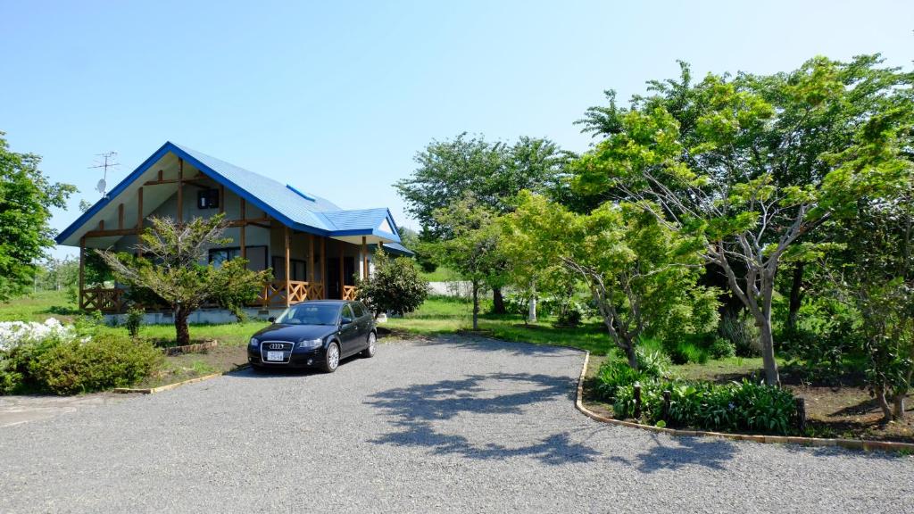 une voiture garée devant une maison dans l'établissement Hoshino Oka in Owani, à Ōwani