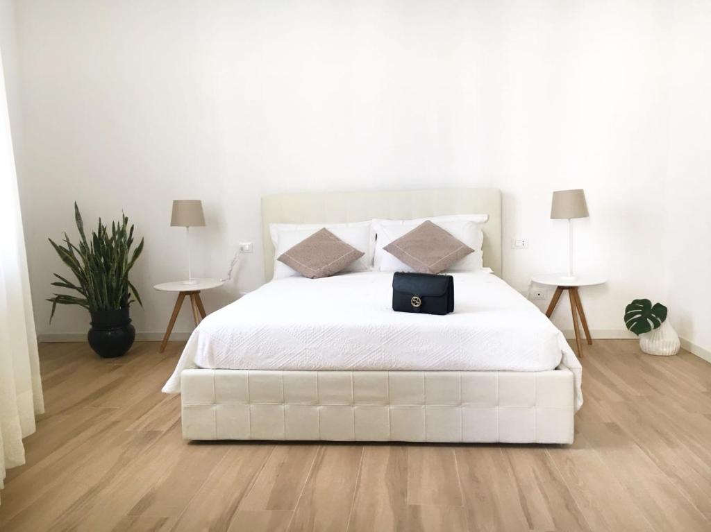 una camera da letto con un letto bianco con una borsa nera sopra di Le Tre Orchidee Florence a Firenze