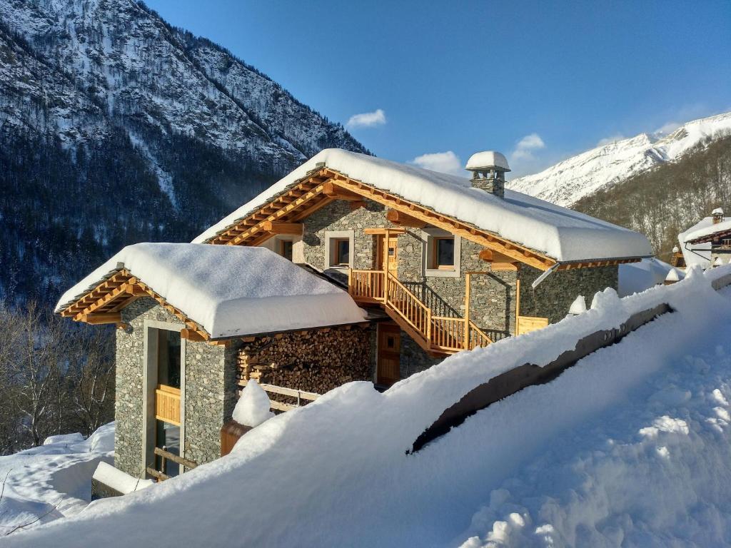 a house covered in snow in the mountains at Delfin Dal Pianhol in Casteldelfino