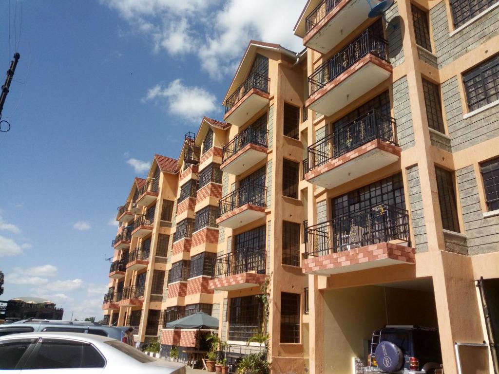 um edifício alto com varandas e um carro estacionado em frente em Savannah Luxury Apartment em Nairobi