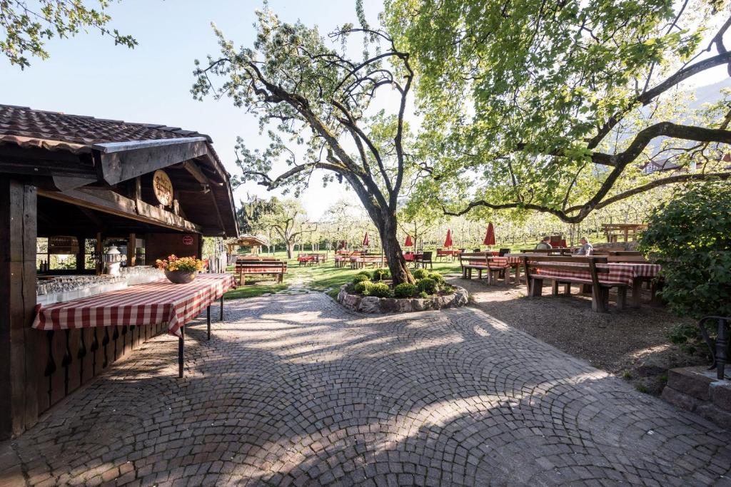a park with tables and benches and a tree at Landgasthof Bad Turmbach in Appiano sulla Strada del Vino