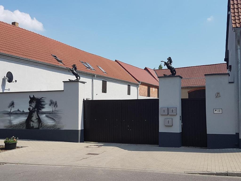 a building with a gate with a painting on it at Pferdehof Jäger in Markranstädt