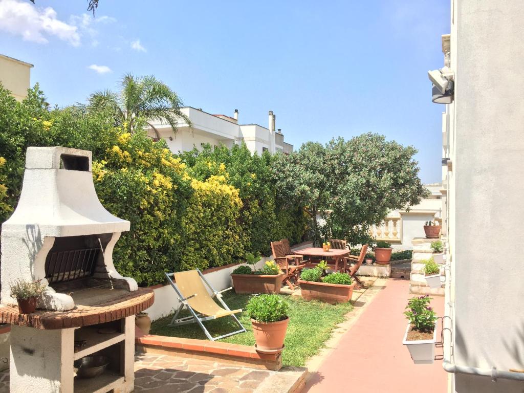 un patio trasero con parrilla, sillas y plantas en Casa Vacanza Zia Dani, en Castro di Lecce