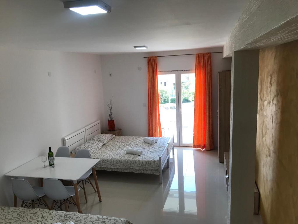 a bedroom with a bed and a table with chairs at Apartments AS in Budva