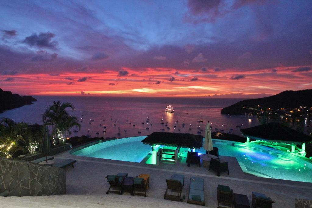 a swimming pool with a view of the ocean at night at Tropical Hideaway in Port Elizabeth