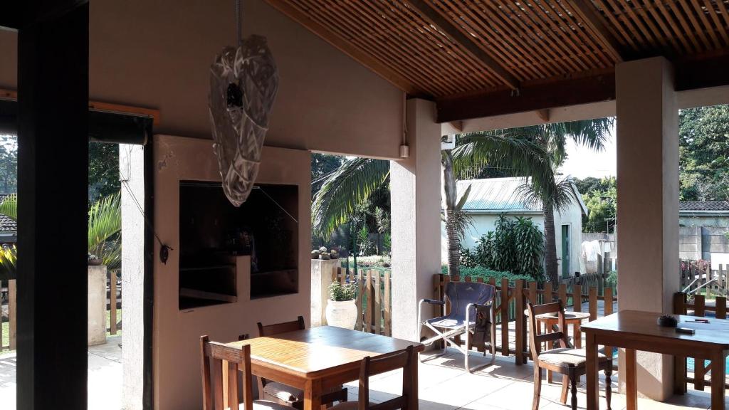 comedor con mesa y sillas en el patio en Jacaranda Guesthouse, en Eshowe