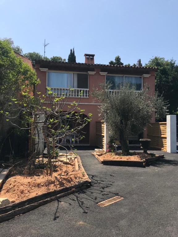 une maison avec deux arbres devant elle dans l'établissement Appartement 300mètres mer Martinengo La Croisette, à Sainte-Maxime