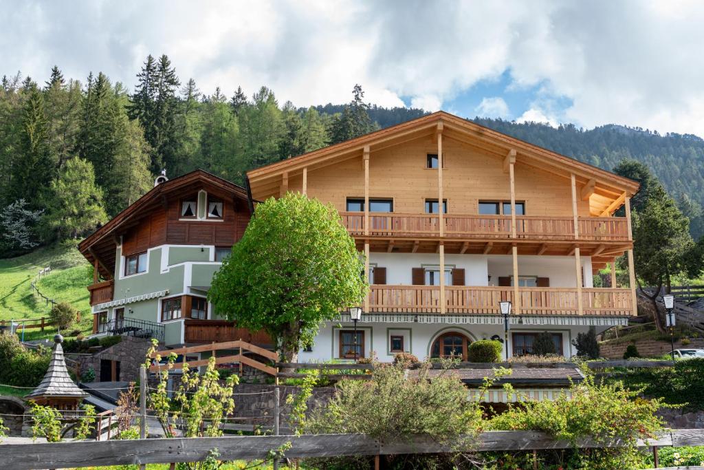 una grande casa in legno con balcone di Garni Halali a Ortisei