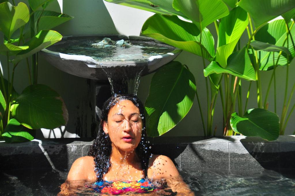 a woman sitting in a bath tub with a fountain at The Patio Yogya in Yogyakarta