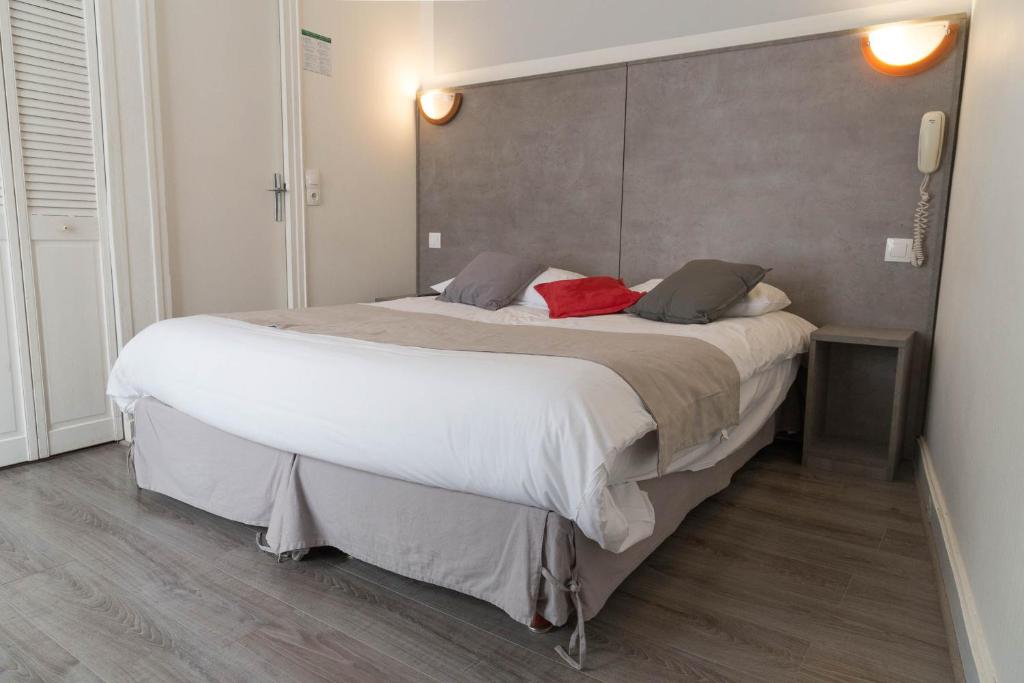 a bedroom with a large bed with white sheets at Panam Hotel PARIS GAMBETTA- Place Gambetta-Mairie du 20 emme in Paris