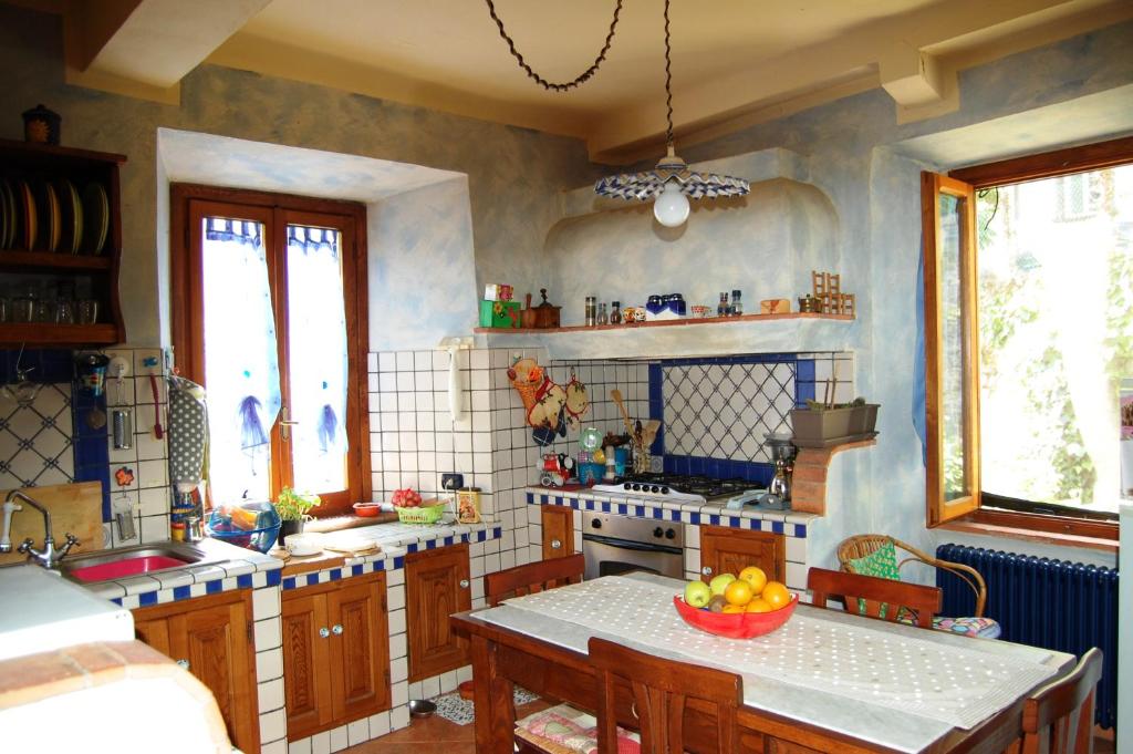 una cocina con una mesa con un bol de fruta. en Casa Arcobaleno, en Bagni di Lucca