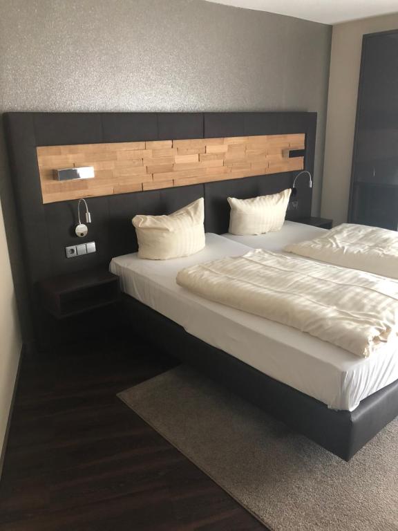 1 dormitorio con 2 camas y cabecero en hotel zentlinde en Mossautal