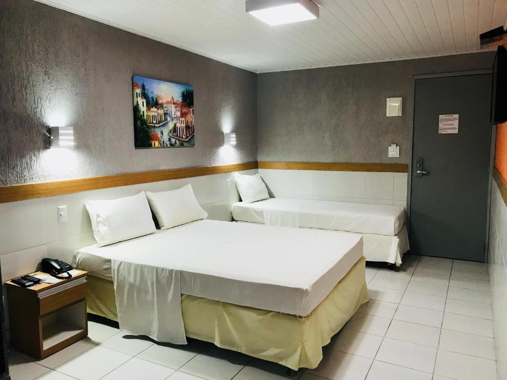 Habitación de hotel con 2 camas y mesa en Inter Hotel en Recife