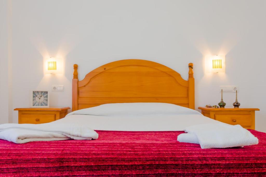a bed with two white towels on top of it at Apartamentos Sanlúcar &amp; Doñana in Sanlúcar de Barrameda
