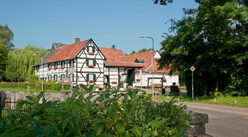 una gran casa blanca con techo rojo en Hotel Hoeve de Plei en Mechelen