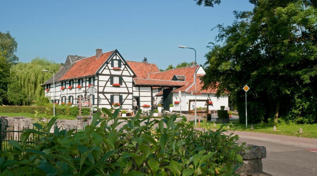 een groot wit huis met een rood dak bij Hotel Hoeve de Plei in Mechelen