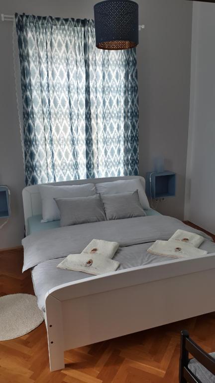 a white bed with towels on it in front of a window at Apartments SAB in Ogulin