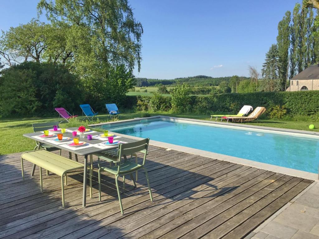 - une table et des chaises à côté de la piscine dans l'établissement La Borlonette, à Durbuy